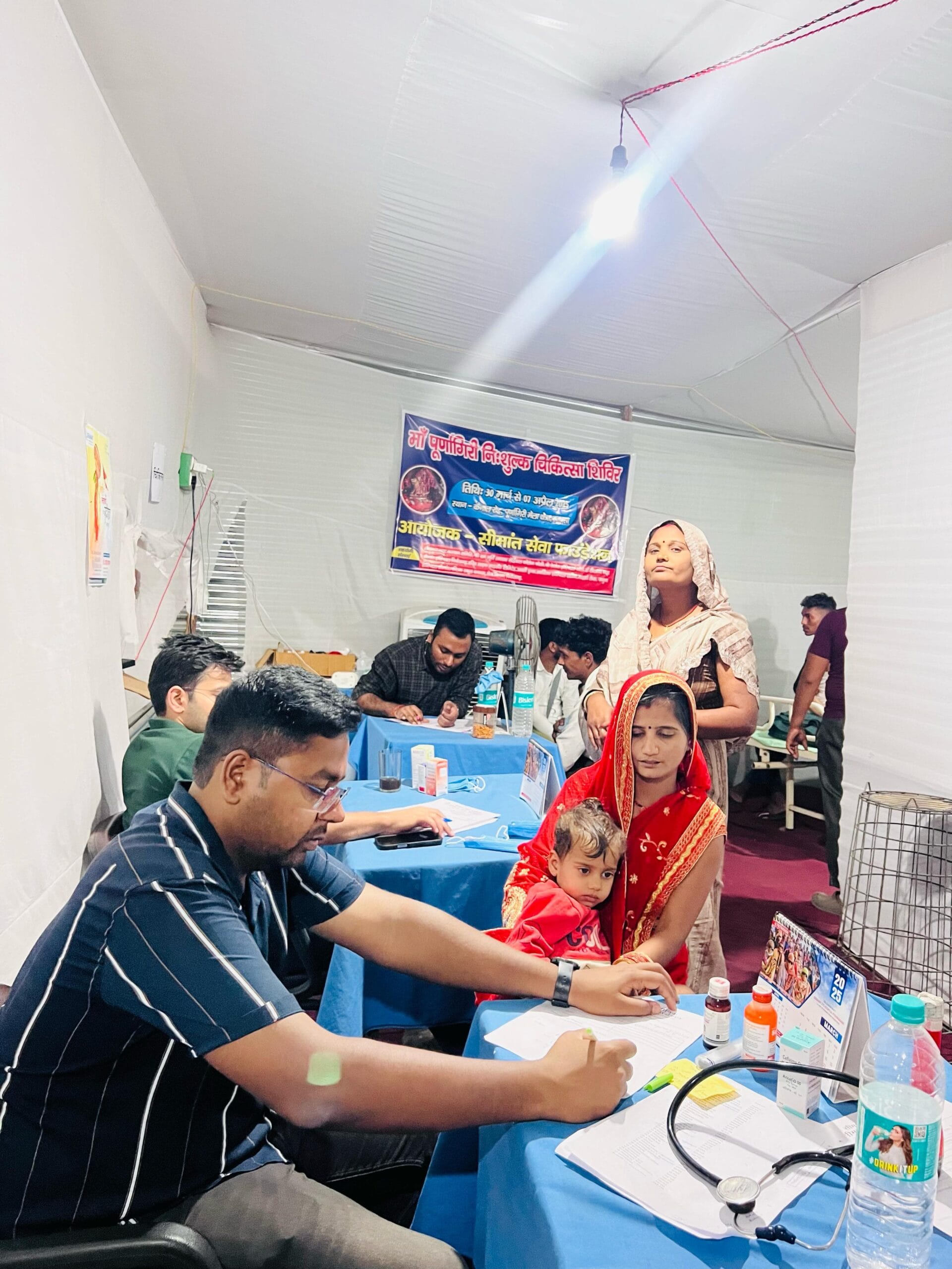 Doctor performing patient health checkup at Maa Purnagiri Nishulk Chikitsa Shivir 2025