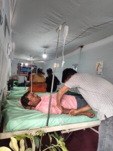 Patient receiving healthcare treatment on bed at Maa Purnagiri free medical camp