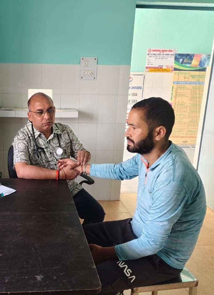 Doctor examining elderly patient during charitable rural healthcare camp in Uttarakhand village